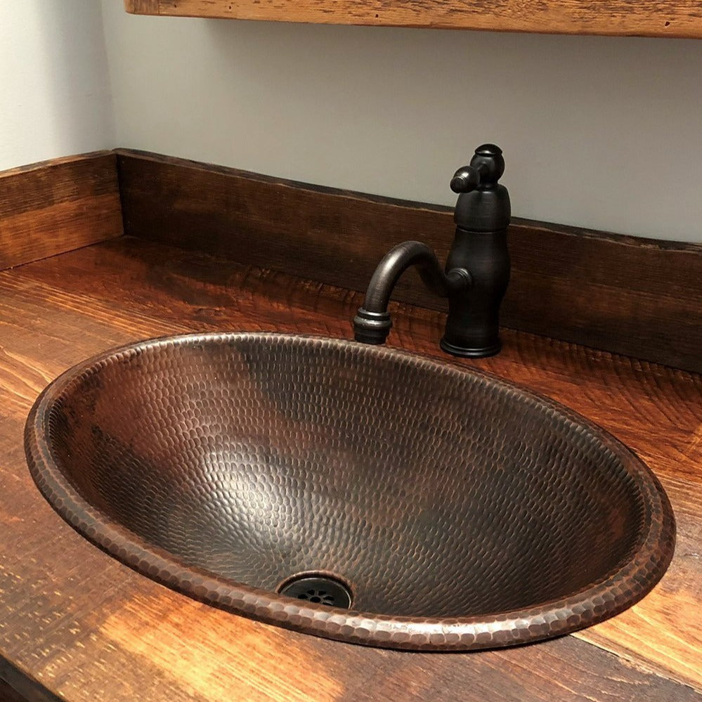Premier Copper Sink Drain in Oil Rubbed Bronze in copper sink with rustic wood counter