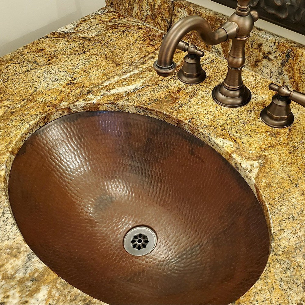 Premier Copper Sink Drain in Oil Rubbed Bronze in copper sink with yellow marble counter and copper faucet