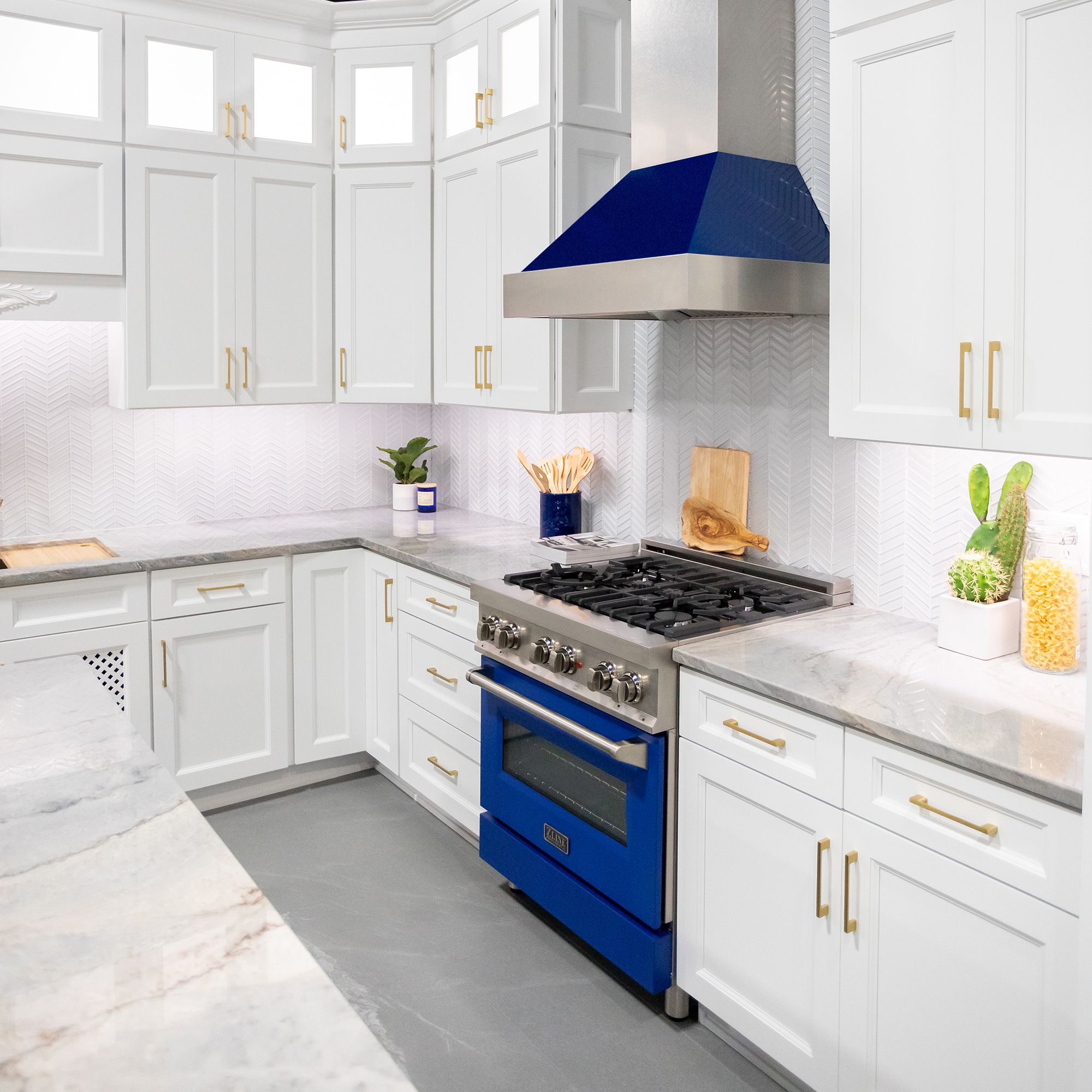 ZLINE Ducted Fingerprint Resistant Stainless Steel Range Hood with Blue Gloss Shell (8654BG) with matching blue gloss range in a white cottage-style kitchen from side.