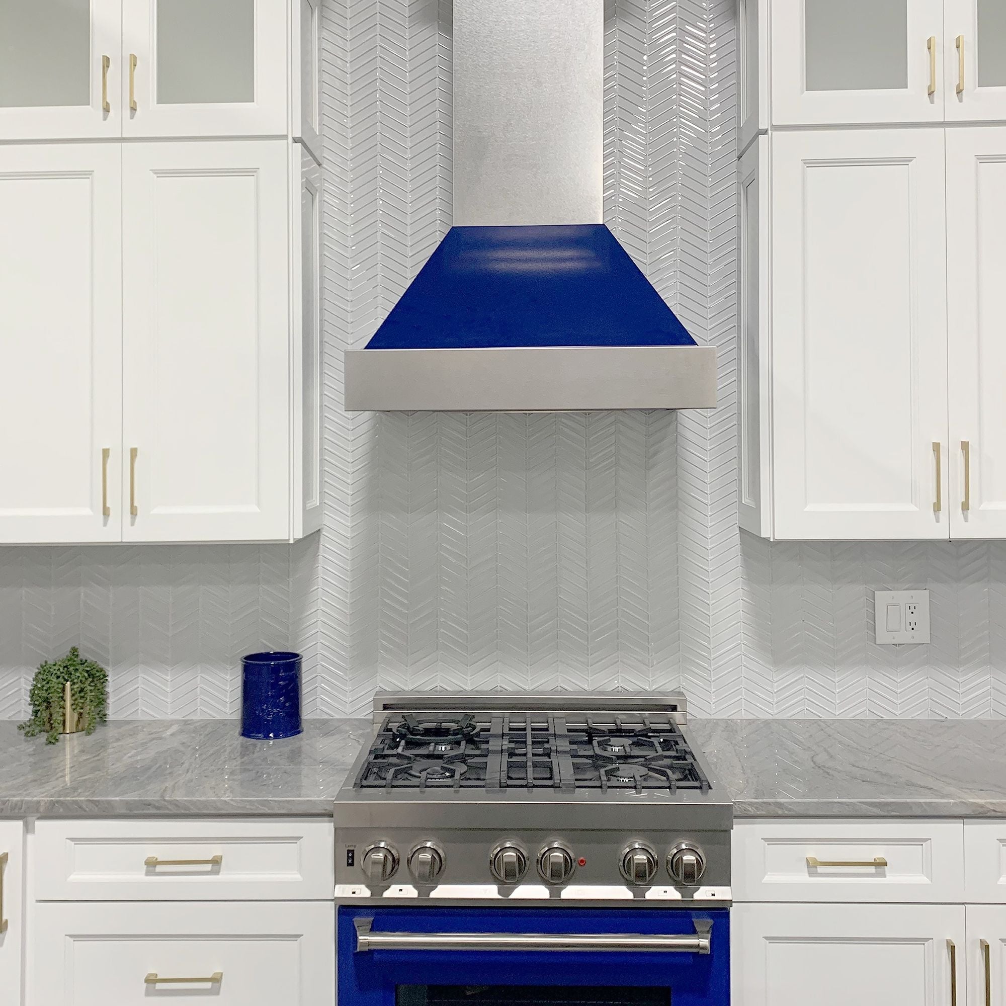 ZLINE Ducted Fingerprint Resistant Stainless Steel Range Hood with Blue Gloss Shell (8654BG) with matching blue gloss range in a white cottage-style kitchen close up.