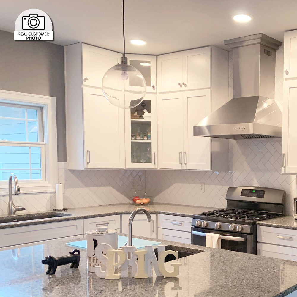ZLINE Professional Ducted Wall Mount Range Hood in a cottage kitchen with white cabinets.