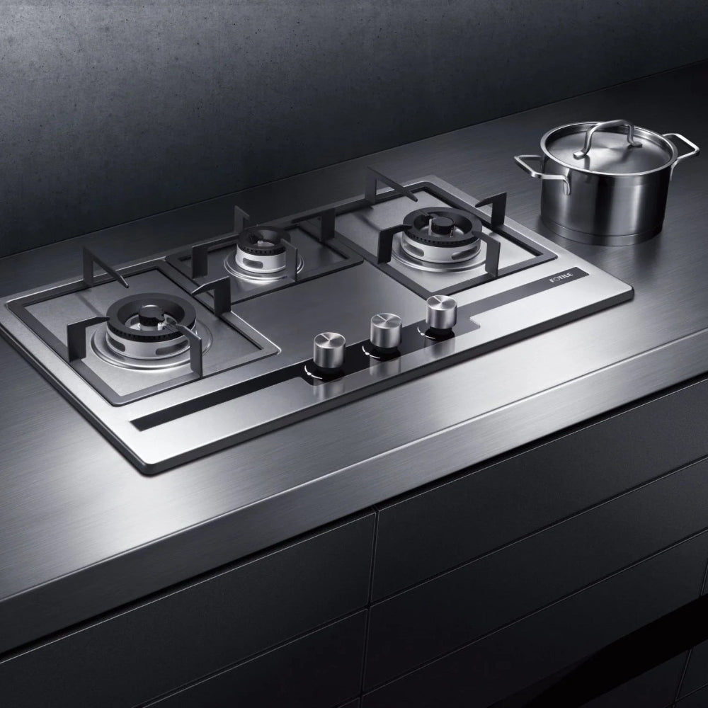 A Fotile EPS Series 31 in. Cooktop with 3 Sealed Burners in Stainless Steel (GAS78307), installed on a dark countertop with a matching pot visible in the background.