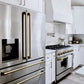 ZLINE Autograph Edition 36 in. 21.6 cu. ft. Counter-Depth French Door Refrigerator with Water and Ice Dispenser in Fingerprint-Resistant Stainless Steel with Champagne Bronze Traditional Handles (RFMZ-W-36-CB) in a modern farmhouse kitchen with stainless steel appliances and white cabinets