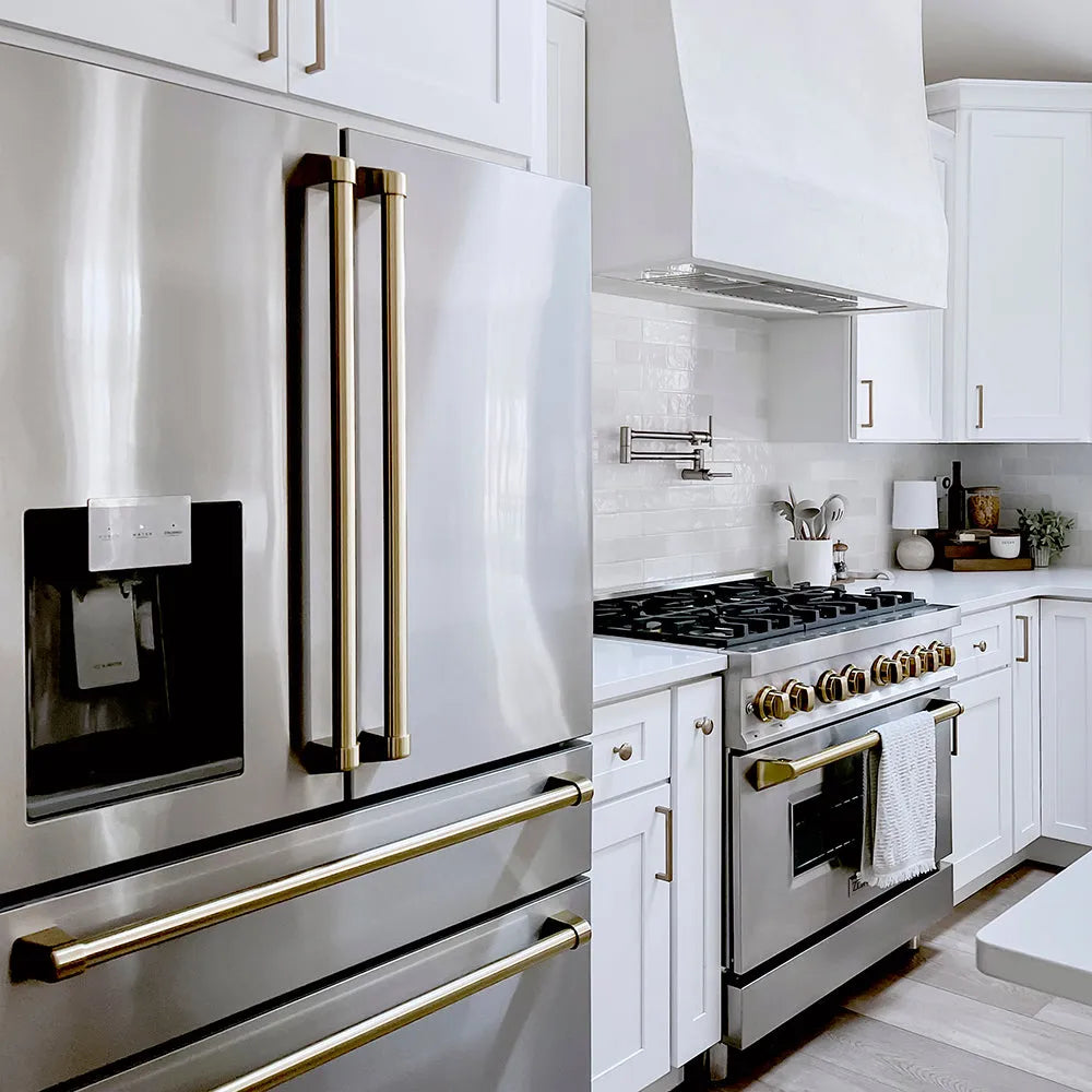 ZLINE Autograph Edition 36 in. 21.6 cu. ft. Counter-Depth French Door Refrigerator with Water and Ice Dispenser in Fingerprint-Resistant Stainless Steel with Champagne Bronze Traditional Handles (RFMZ-W-36-CB) in a modern farmhouse kitchen with stainless steel appliances and white cabinets