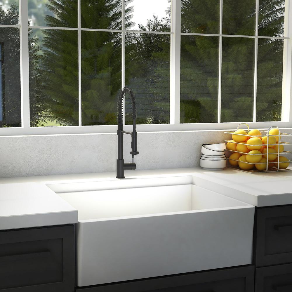 ZLINE Apollo Kitchen Faucet (APL-KF) Matte Black in a modern kitchen with a white farmhouse sink and a window view of greenery.