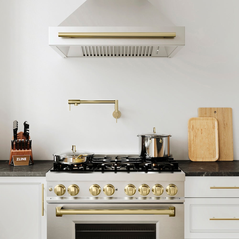 ZLINE Autograph Edition 36 in. Kitchen Package with Stainless Steel Dual Fuel Range and Range Hood with Champagne Bronze Accents (2AKP-RARH36-CB) lifestyle, in a luxury cottage-style kitchen with white cabinets and matching appliances.