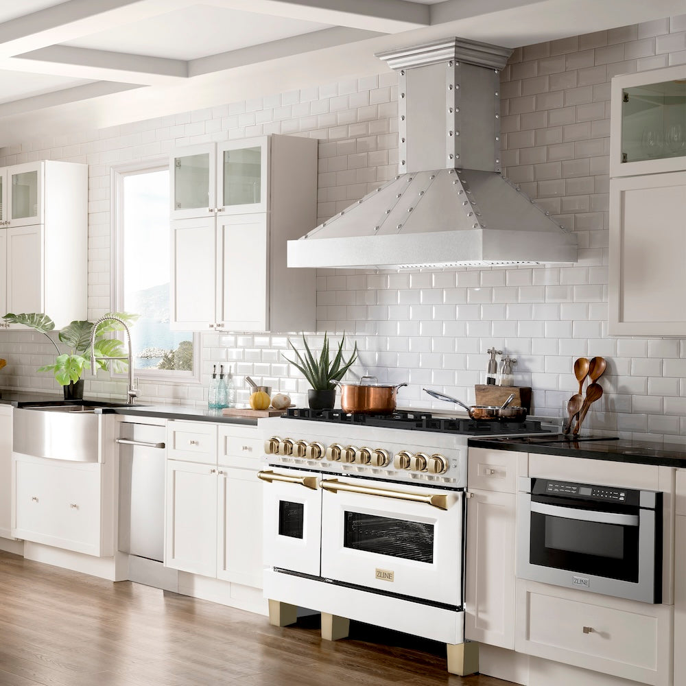 ZLINE Autograph Edition 48 in. 6.0 cu. ft. Legacy Dual Fuel Range with 7 Burner Gas Cooktop and 2 Electric Ovens in Satin Stainless Steel with White Matte Doors and Polished Gold Accents (RASZ-WM-48-G) in a kitchen with white cabinets and a tiled backsplash.