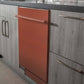ZLINE 24 in. Copper Top Control Built-In Dishwasher with Stainless Steel Tub and Modern Style Handle, 52dBa (DW-C-24) in a modern-style kitchen with grey cabinets and dark countertops.