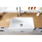 Kingston Brass 33 in. Solid Surface White Stone Apron-Front Single Bowl Farmhouse Kitchen Sink with Strainer in Matte White (GKFA331810DS) with wooden countertop and tiled wall
