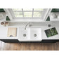 Kingston Brass Arcticstone 33 in. Solid Surface White Stone Apron-Front Double Bowl Farmhouse Kitchen Sink with Strainers in Matte/Glossy White (GPFA331810BCD) with a window above it in a modern kitchen setting.