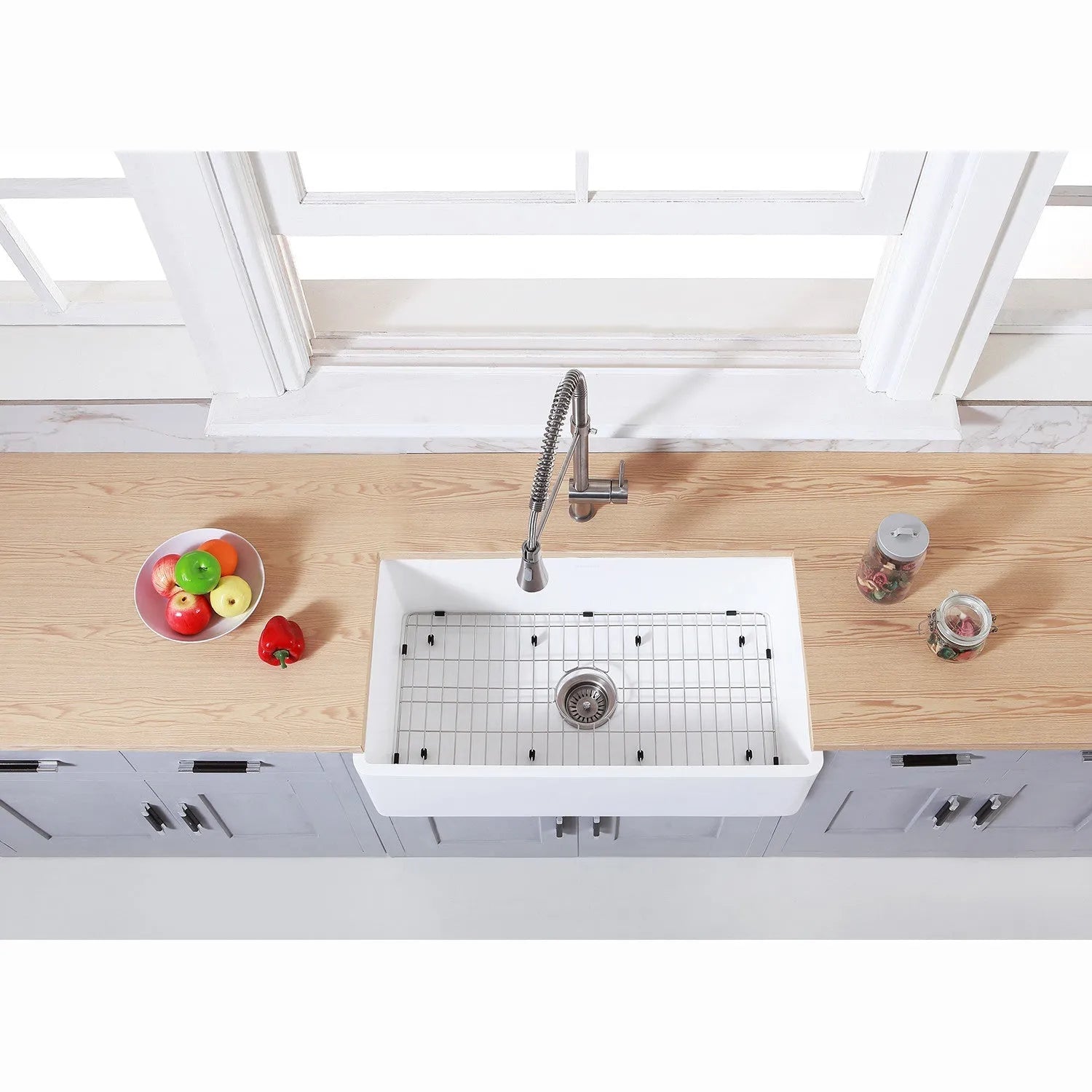 Farmhouse kitchen with a Kingston Brass 33 in. Farmhouse Apron Front Kitchen Sink with Strainer and Grid in Matte White (KGKFA331810BC) and wooden countertop.