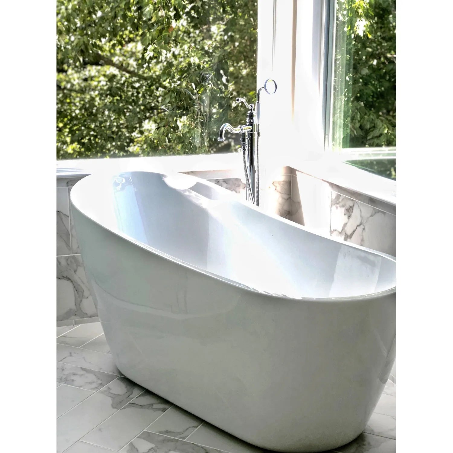 Kingston Brass English Country Freestanding Tub Faucet with Hand Shower (KS7131ABL) Polished Chrome above a white freestanding bathtub in a bathroom with large windows and greenery outside.