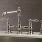 Kingston Brass English Country Kitchen Faucet with Side Sprayer (KS7276ALBS) Polished Nickel on a sink with a neutral background