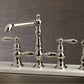 Kingston Brass English Country Kitchen Faucet with Side Sprayer (KS7276ALBS) Polished Nickel on a sink with a neutral background