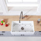 Kingston Brass 33 in. Solid Surface White Stone Apron-Front Single Bowl Farmhouse Kitchen Sink with Strainer and Grid in Matte White (KGKFA331810RM) on a wooden countertop
