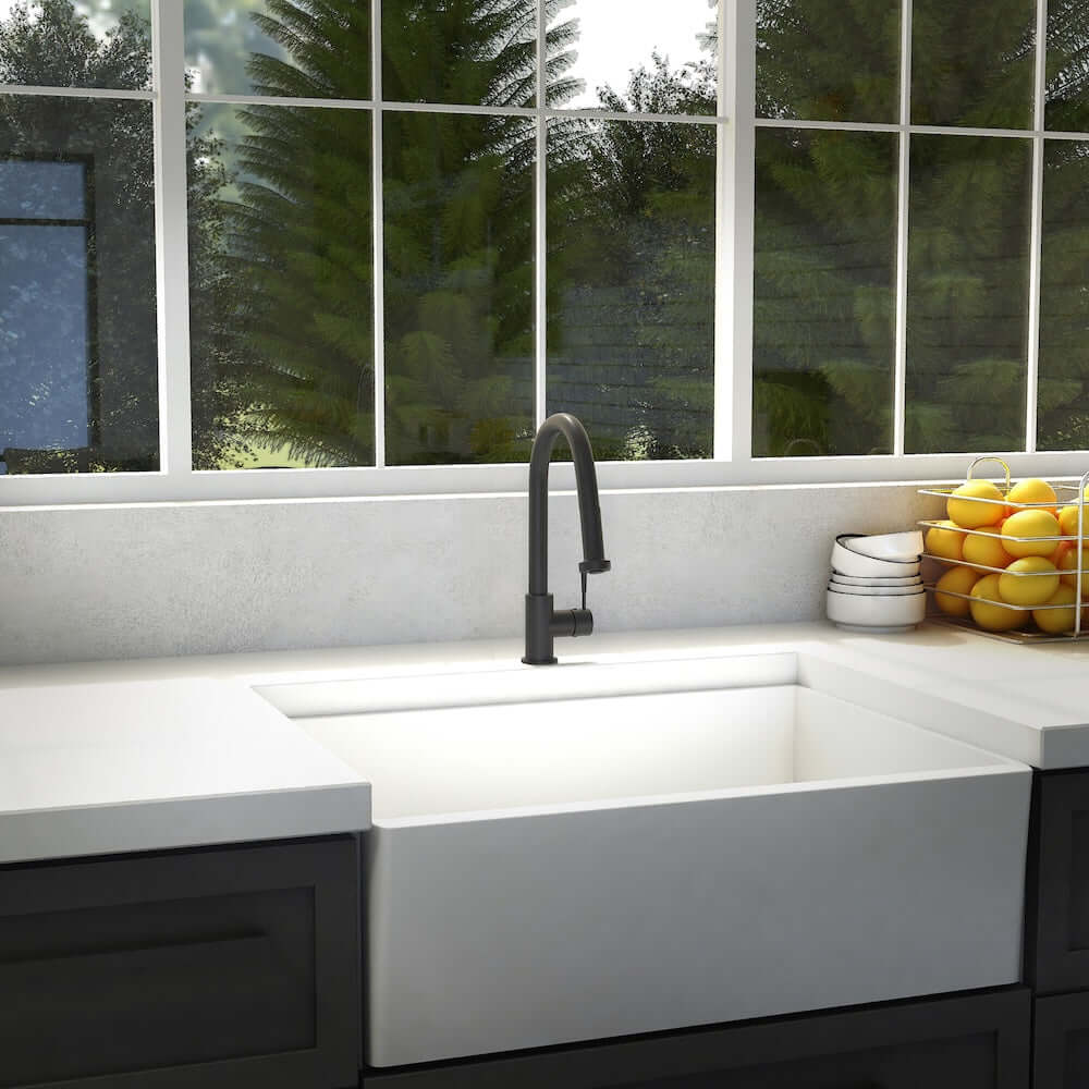 Modern kitchen with a white sink and ZLINE Monet Kitchen Faucet in Matte Black (MON-KF-MB), large window with greenery outside.