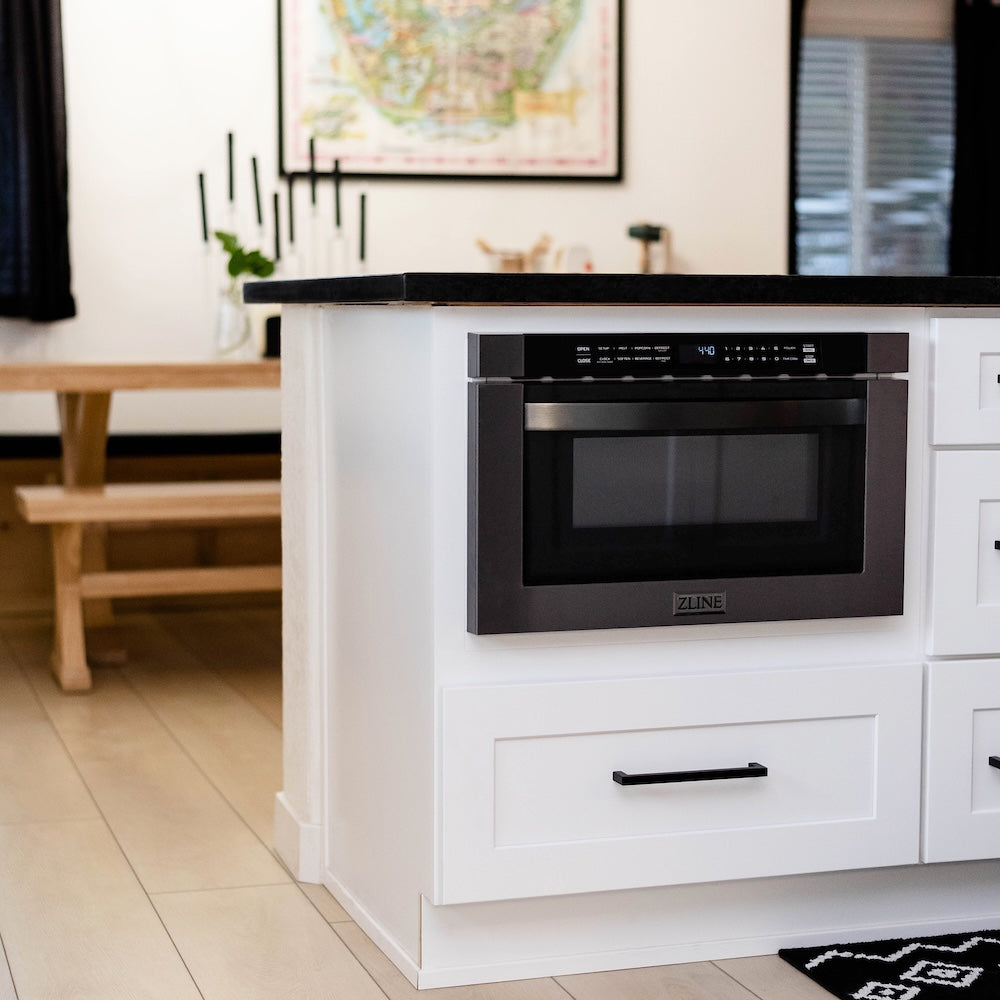 Modern kitchen with white cabinetry, black countertop, and ZLINE 24 in. 1.2 cu. ft. Built-in Microwave Drawer in Black Stainless Steel (MWD-1-BS).
