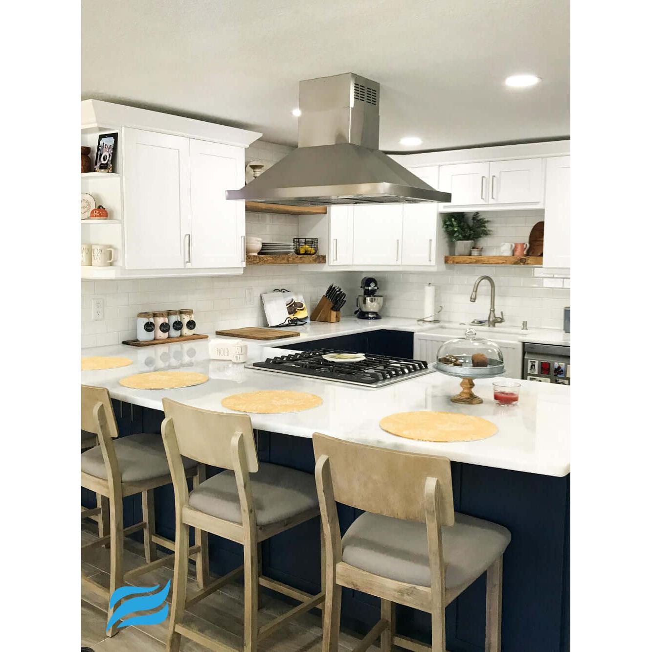 Proline Island Mount Ducted Range Hood in Stainless Steel (PLFI 520) in a kitchen with white countertops, white cabinets, and wooden chairs.