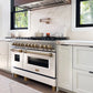 Farmhouse kitchen with a ZLINE Autograph Edition 48 in. 6.0 cu. ft. Legacy Dual Fuel Range with 7 Burner Gas Cooktop and 2 Electric Ovens in Stainless Steel with White Matte Doors and Champagne Bronze Accents (RAZ-WM-48-CB) and marble backsplash