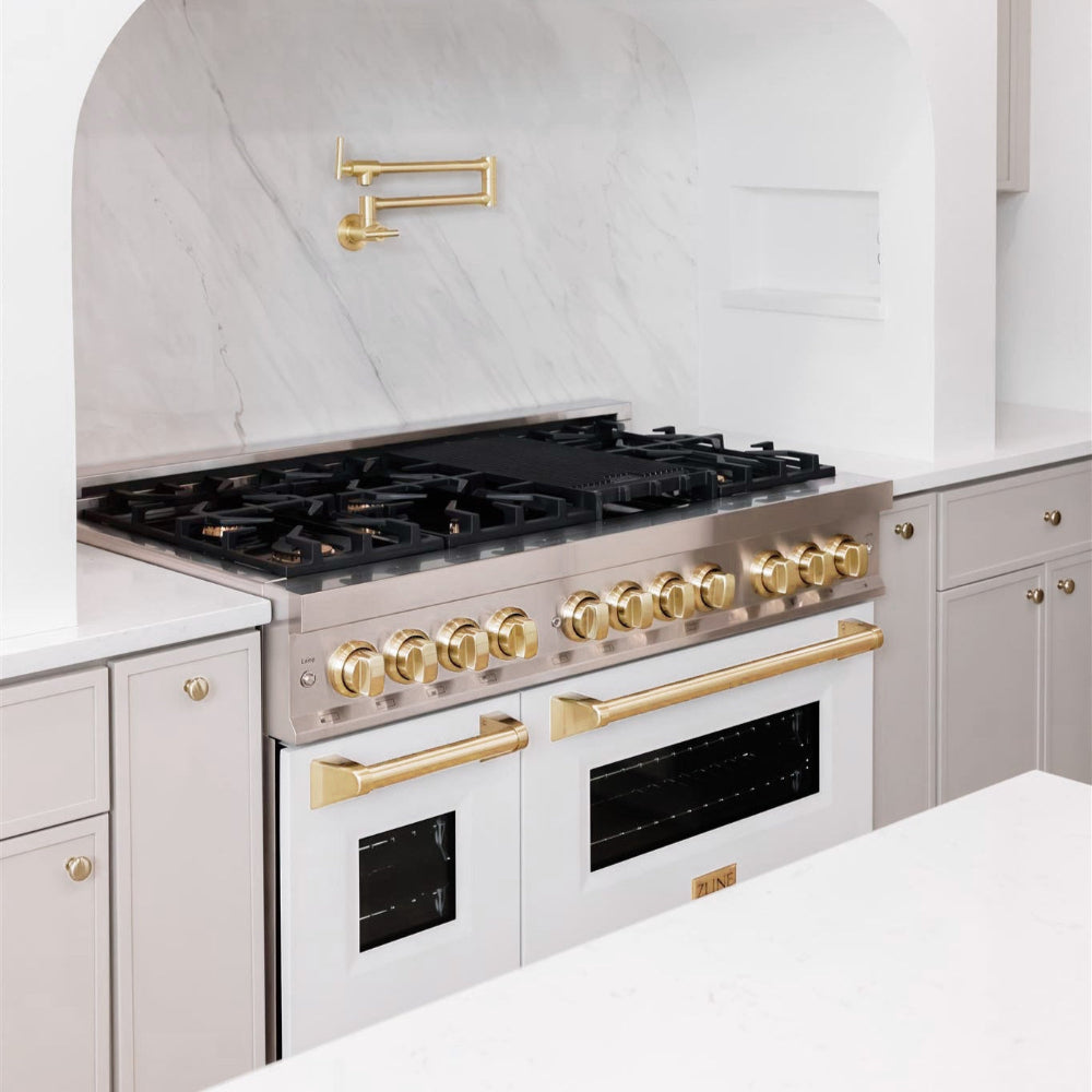 ZLINE Autograph Edition 48 in. 6.0 cu. ft. Legacy Dual Fuel Range with 7 Burner Gas Cooktop and 2 Electric Ovens in Stainless Steel with White Matte Doors and Polished Gold Accents (RAZ-WM-48-G) in a kitchen  with gold fixtures against a white backsplash