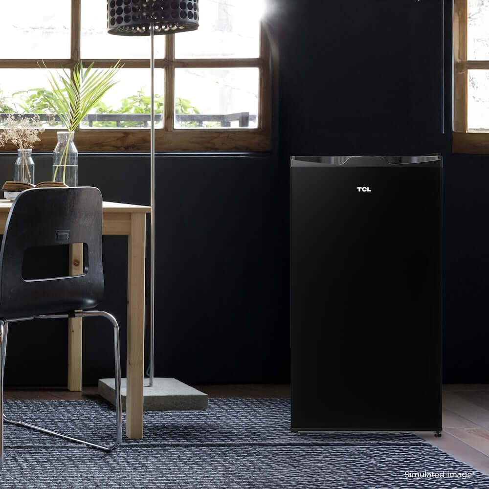 TCL 18 in. 3.1 Cu. Ft. Compact Single Door Mini Fridge in Black (TRM31S4AB) in a room with a dining table and chairs.