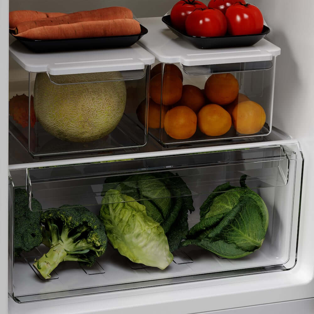 Fridge compartments containing fruits, vegetables, and a melon.