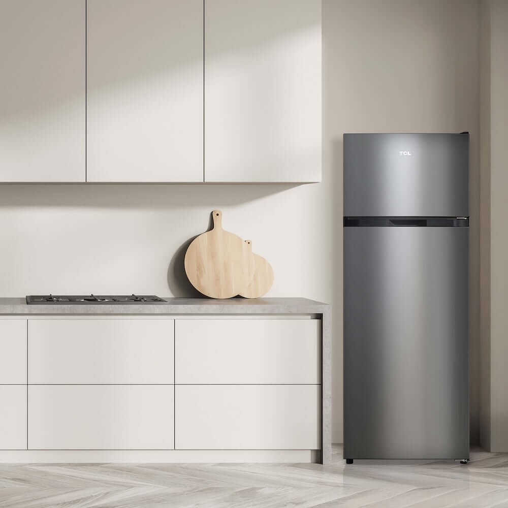 Modern kitchen with a TCL 22 in. 7.3 Cu. Ft. Compact Top Freezer Refrigerator in Silver (TRT07T4AL) and light-colored cabinets.