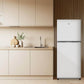 TCL 24 in. 11.6 Cu. Ft. Top Freezer Counter-Depth Refrigerator in White (TRT12T4AW) in a modern kitchen with wooden cabinets and a countertop with kitchen items.