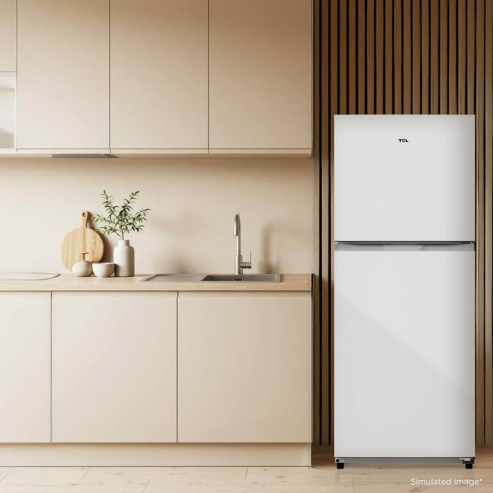TCL 24 in. 11.6 Cu. Ft. Top Freezer Counter-Depth Refrigerator in White (TRT12T4AW) in a modern kitchen with wooden cabinets and a countertop with kitchen items.