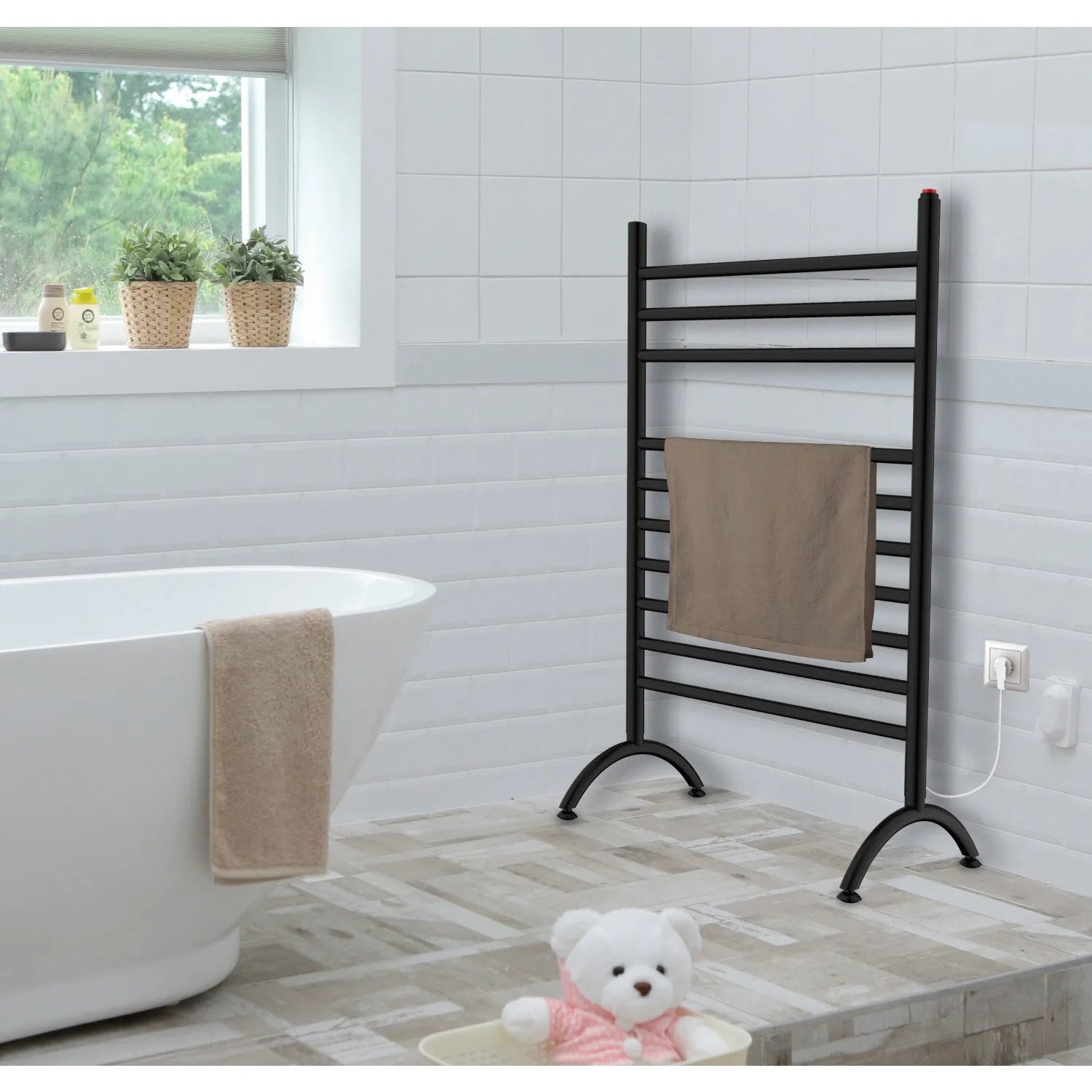 Bathroom with Kingston Brass Templeton Freestanding Plug-In Towel Warmer Matte Black, bathtub, and teddy bear on a wooden floor.