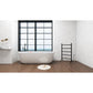 Modern bathroom with a freestanding bathtub, Kingston Brass Templeton Freestanding/Wall Mount Hardwired or Plug-In Towel Warmer Matte Black, and large window.