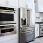 Modern kitchen with stainless steel appliances including a refrigerator and a ZLINE Autograph Edition 30 in. Professional True Convection Single Wall Oven with Air Fry and Self Clean in Stainless Steel with Champagne Bronze Handle (WASZ-30-CB).