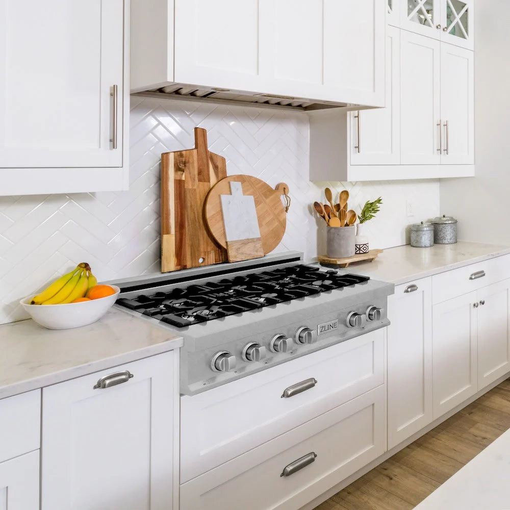Modern kitchen with white cabinets, stainless steel cooktop.