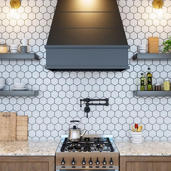 A kitchen interior featuring a white hexagonal tile backsplash, dark wood cabinets, a black tapered range hood, and a gas cooktop with a kettle on the stovetop.