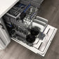 ZLINE 24 in. Tallac Series 3rd Rack Dishwasher with Auto Door Open Drying, 51dBa, Stainless Steel Panel (DWV-304-24) with multiple racks loaded with dishes, including bowls, plates, and glassware, shown in a kitchen setting with wood flooring.