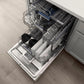 ZLINE 24 in. Tallac Series 3rd Rack Dishwasher with Auto Door Open Drying, 51dBa, Stainless Steel Panel (DWV-304-24) shown from above inside a kitchen, with two racks loaded with dishes, glassware, and utensils on a light wood floor and white countertop.