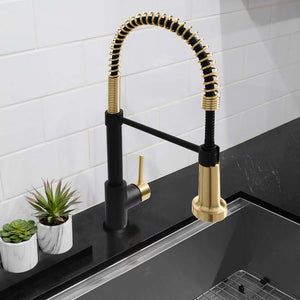 ZLINE Autograph Edition Apollo Pull Down Spring Single Handle Kitchen Faucet in Matte Black and Champagne Bronze (APL-KF-ZMBCB) on a black countertop with a white tiled wall background.