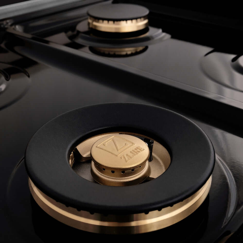 ZLINE Autograph Edition 60 in. 7.4 cu. ft. Dual Fuel Range with Gas Stove and Electric Oven in DuraSnow® Stainless Steel with Champagne Bronze Accents (RASZ-SN-60-CB) brass burners close-up on cooktop without grates.