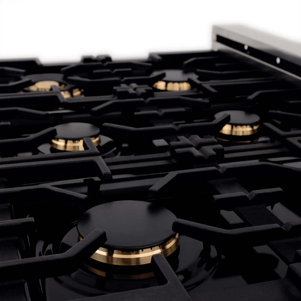 ZLINE Autograph Edition 36 in. 4.6 cu. ft. Dual Fuel Range with Gas Stove and Electric Oven in Fingerprint Resistant Stainless Steel with White Matte Door and Matte Black Accents (RASZ-WM-36-MB) close-up, brass burners on black porcelain cooktop with grates from side.