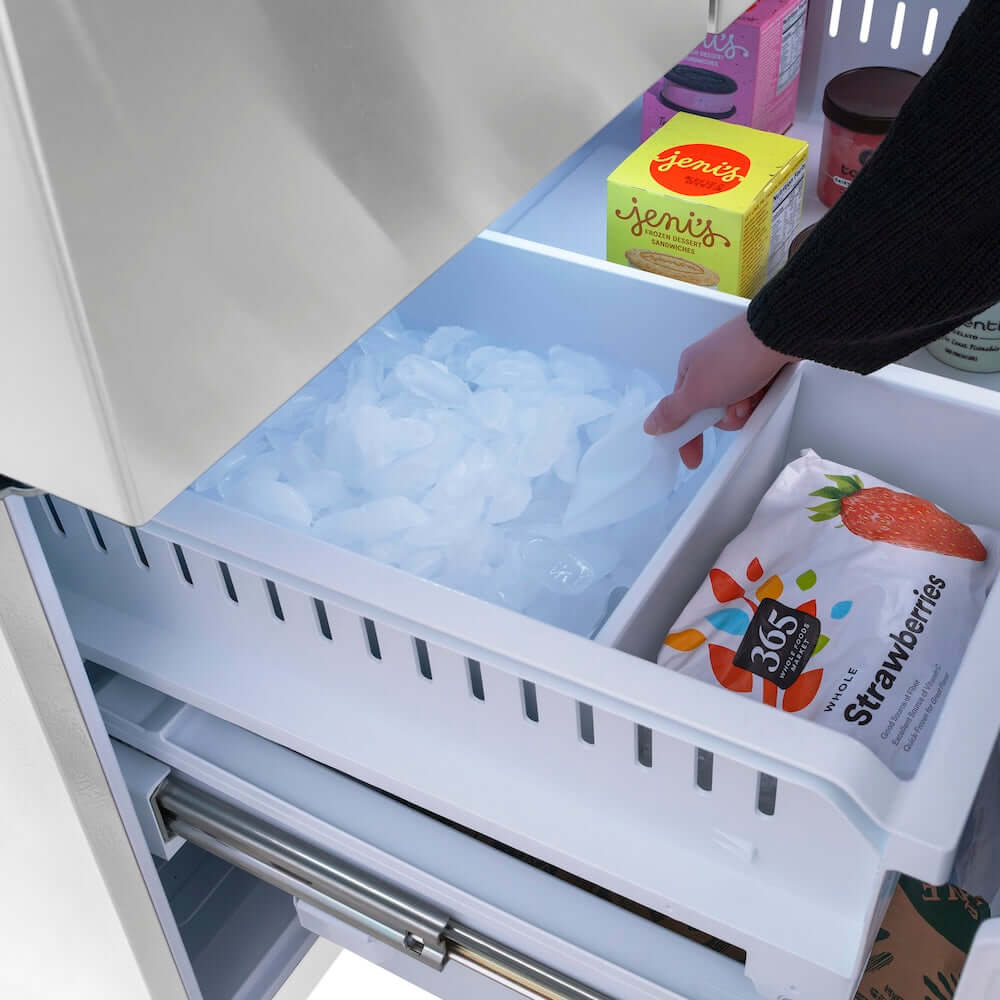 ZLINE Autograph Edition 36 in. 28.9 cu. ft. Standard-Depth French Door External Water Dispenser Refrigerator with Dual Ice Maker in Fingerprint-Resistant Stainless Steel and Polished Gold Helix Handles (RSMZ-W-36-KG) person scooping ice from ice cube tray in bottom freezer next to frozen food packages.