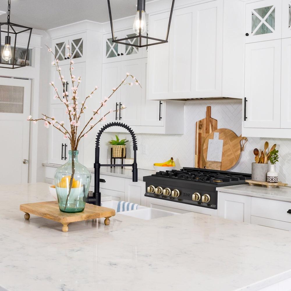 ZLINE Autograph Edition 30 in. Legacy Gas Rangetop with 4 Burners and Porcelain Cooktop in Black Stainless Steel with Polished Gold Accents (RTBZ-30-G) in a luxury cottage-style kitchen from side.