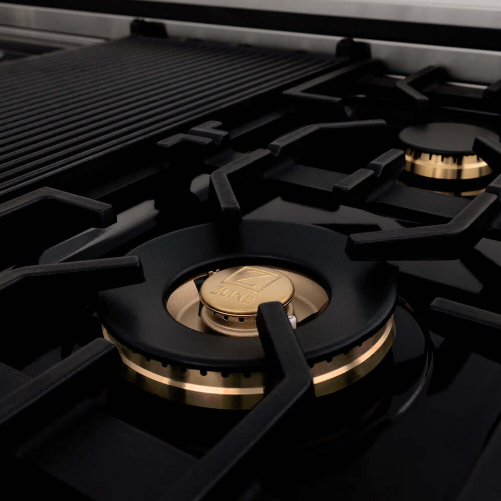 ZLINE Autograph Edition 60 in. 7.4 cu. ft. Legacy Dual Fuel Range with 9 Burner Gas Cooktop and 2 Electric Convection Ovens in Stainless Steel and Matte Black Accents (RAZ-60-MB) detail, brass burners on gas cooktop.
