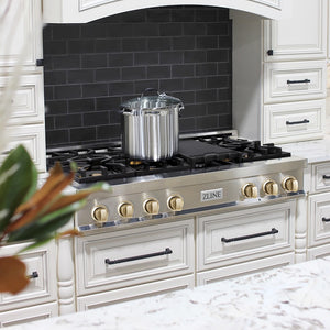Stainless steel pot on a ZLINE Autograph Edition 48 in. Legacy Gas Rangetop with 7 Burners and Porcelain Cooktop in Stainless Steel with Polished Gold Accents (RTZ-48-G) in a kitchen with white cabinets and black tiled backsplash.