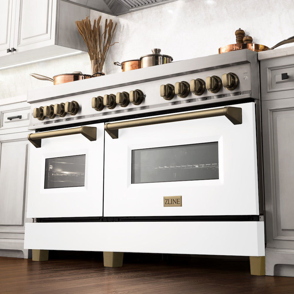 ZLINE Autograph Edition 60 in. 7.4 cu. ft. Legacy Dual Fuel Range with 9 Burner Gas Cooktop and 2 Electric Convection Ovens in Stainless Steel with White Matte Doors and Champagne Bronze Accents (RAZ-WM-60-CB) in a luxury kitchen.