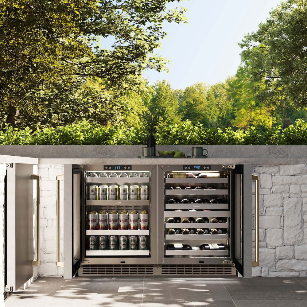 ZLINE Autograph Edition 24 in. Touchstone Dual Zone 44 Bottle Wine Cooler With DuraSnow® Stainless Steel Glass Door And Champagne Bronze Handle (RWDOZ-SN-24-CB) in a luxury outdoor kitchen, front, open with beverages inside.