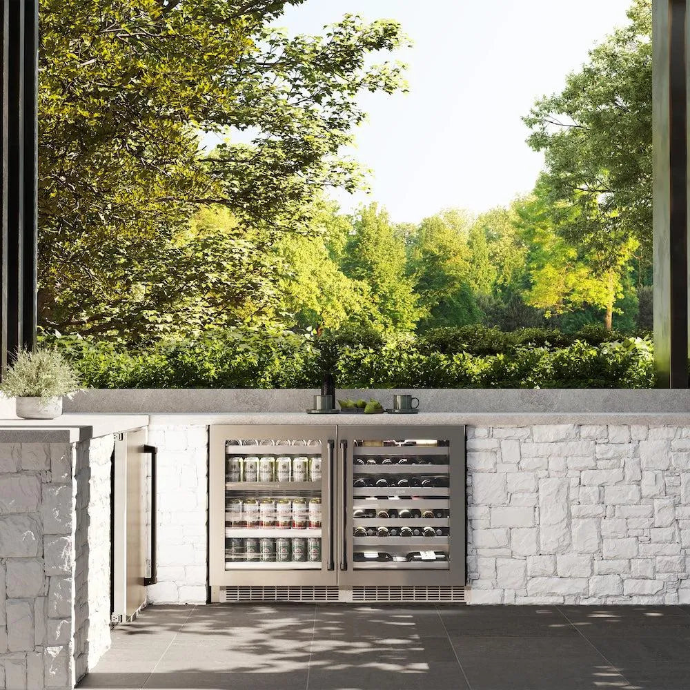 Outdoor kitchen with ZLINE Autograph Edition 24 in. Touchstone 151 Can Beverage Fridge with Stainless Steel Glass Door and Matte Black Handle (RBSOZ-GS-24-MB) and stone wall, surrounded by greenery