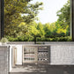 ZLINE Autograph Edition 24 in. Touchstone Dual Zone 44 Bottle Wine Cooler with Stainless Steel Glass Door and Champagne Bronze Handle (RWDOZ-GS-24-CB) in an outdoor kitchen with stone walls and greenery