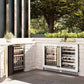 ZLINE Autograph Edition 24 in. Touchstone 151 Can Beverage Fridge With White Matte Glass Door And Polished Gold Handle (RBSOZ-WM-24-G) side, in an outdoor patio area against a stone wall and greenery.