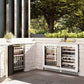 ZLINE Autograph Edition 24 in. Touchstone Dual Zone 44 Bottle Wine Cooler With White Matte Glass Door And Champagne Bronze Handle (RWDOZ-WM-24-CB) side, in an outdoor patio area against a stone wall and greenery.