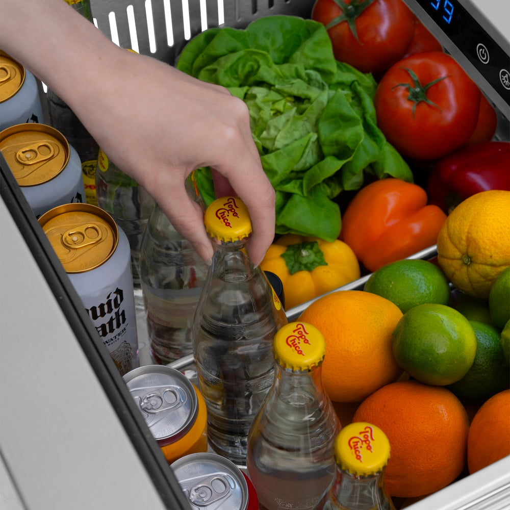 ZLINE Autograph Edition 24 in. Touchstone 168 Can Outdoor-Rated Dual Refrigerator Drawer with Stainless Steel Doors and Polished Nickel Helix Handles (RDSOZ-ST-24-KPN) refrigeration compartment open with fruits, vegetables, and drinks inside.